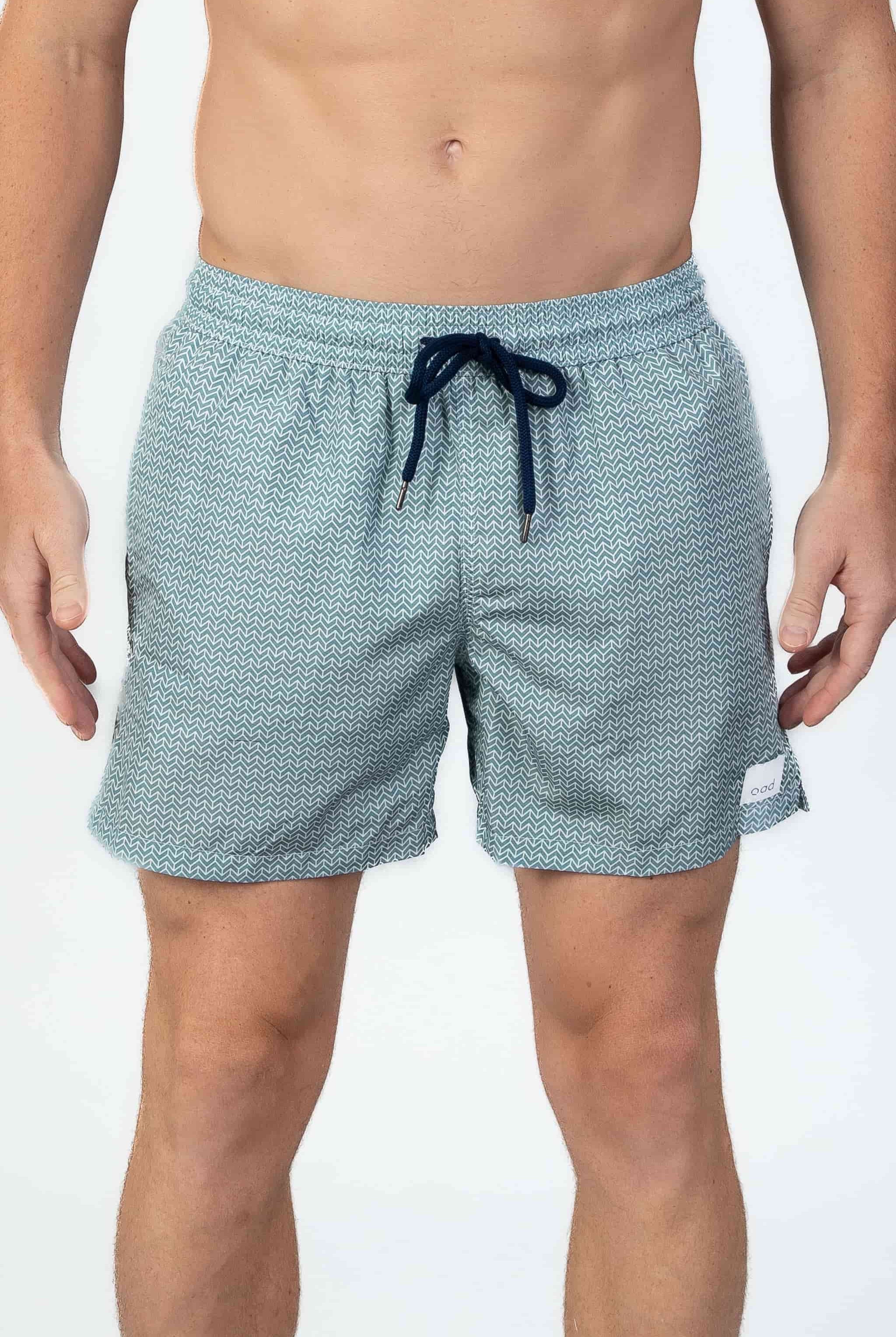 Arrow patterned swim shorts in Aqua turquoise with a navy drawstring on a white background