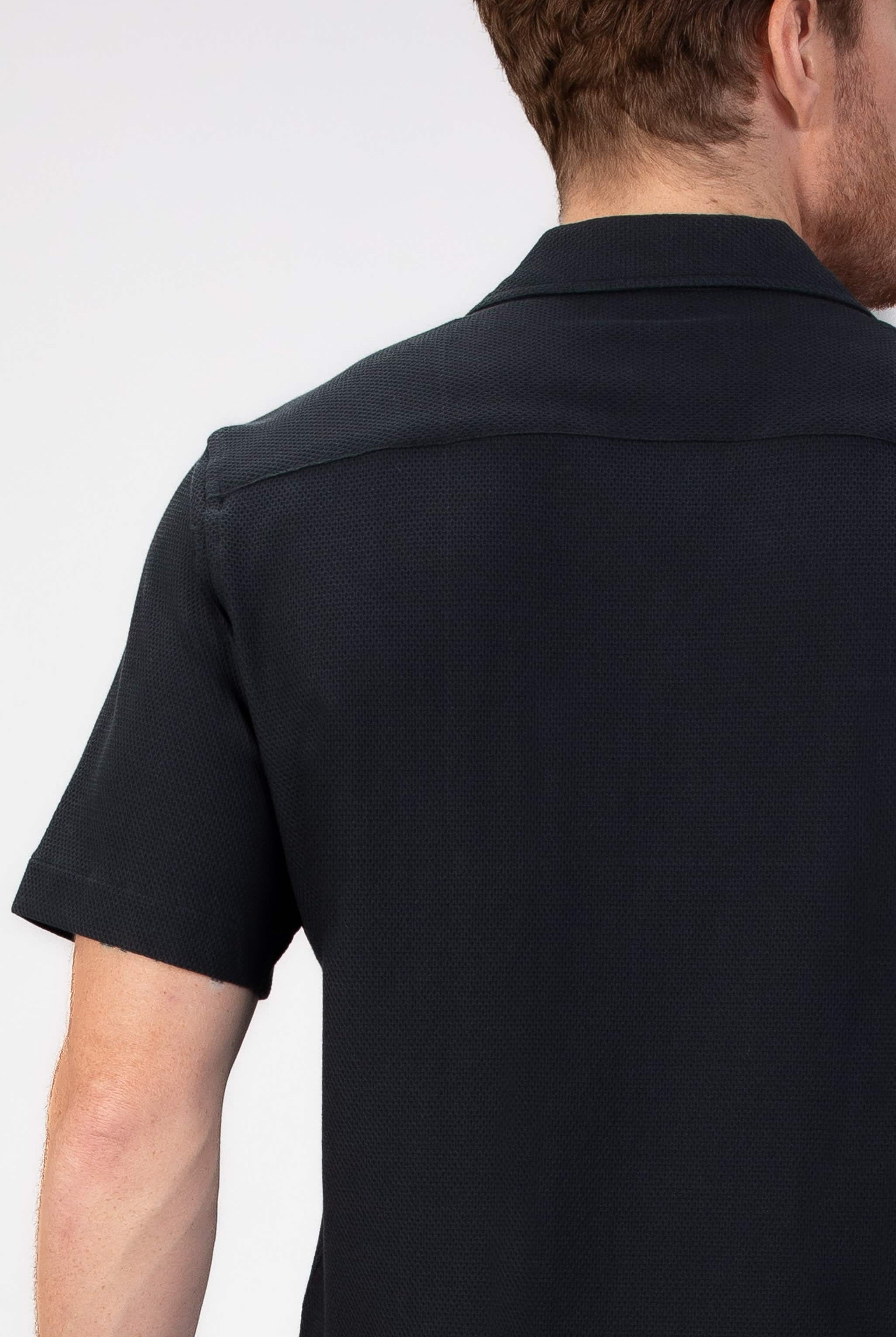 Person wearing a black short-sleeve shirt on a white background