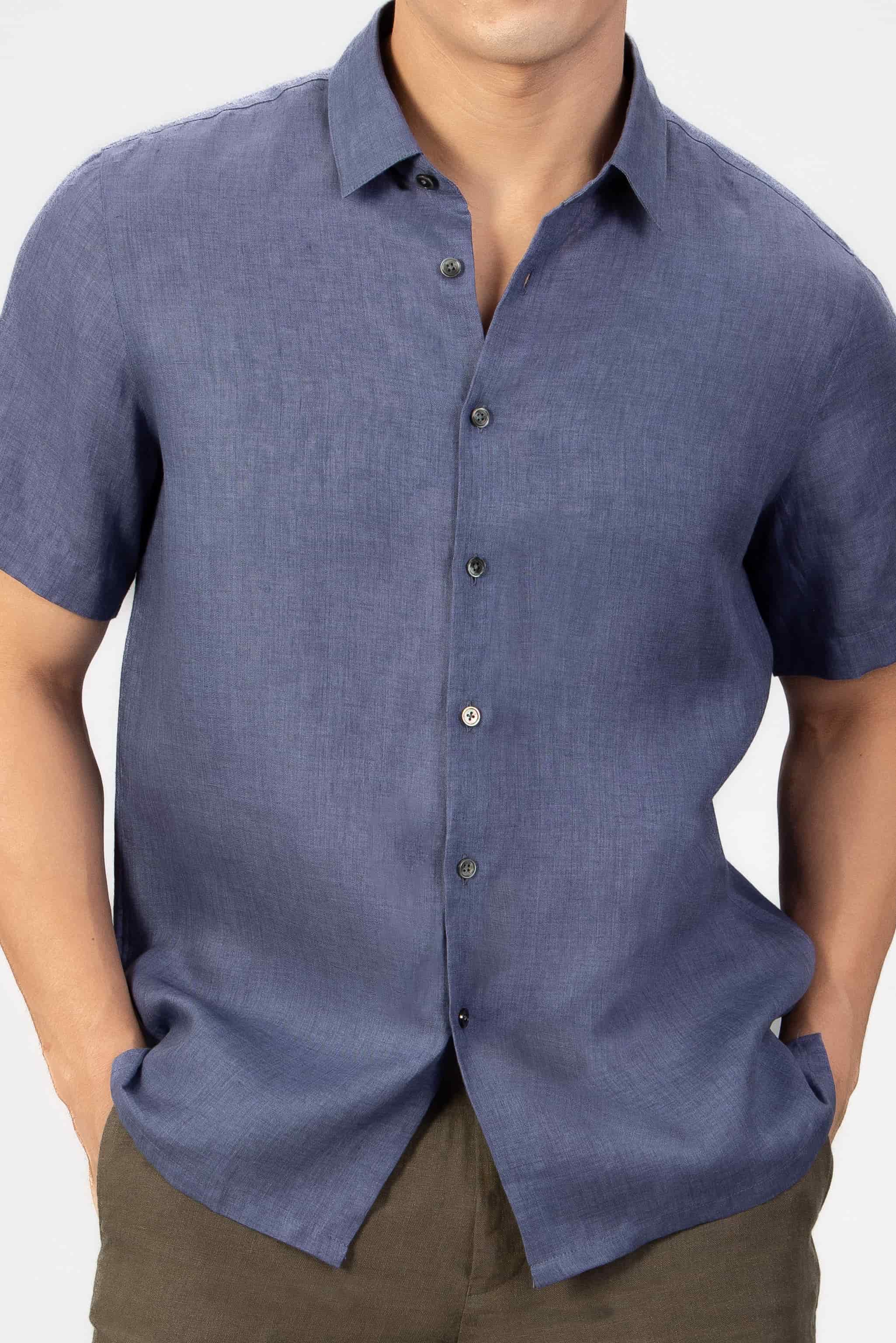 Man wearing a blue short-sleeve shirt against a white background