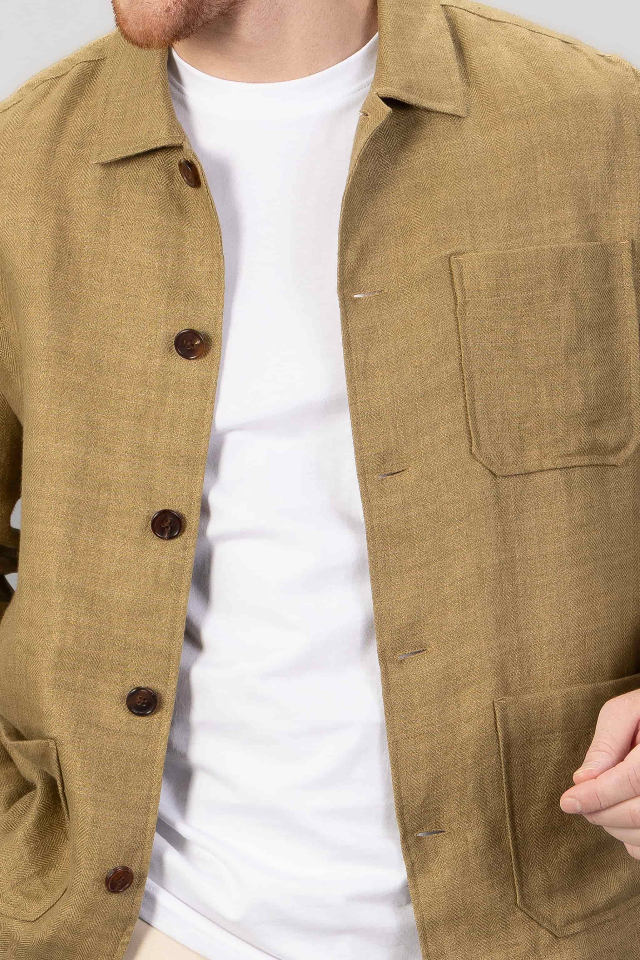Close-up of a person wearing a brown over-shirt over a white t-shirt.
