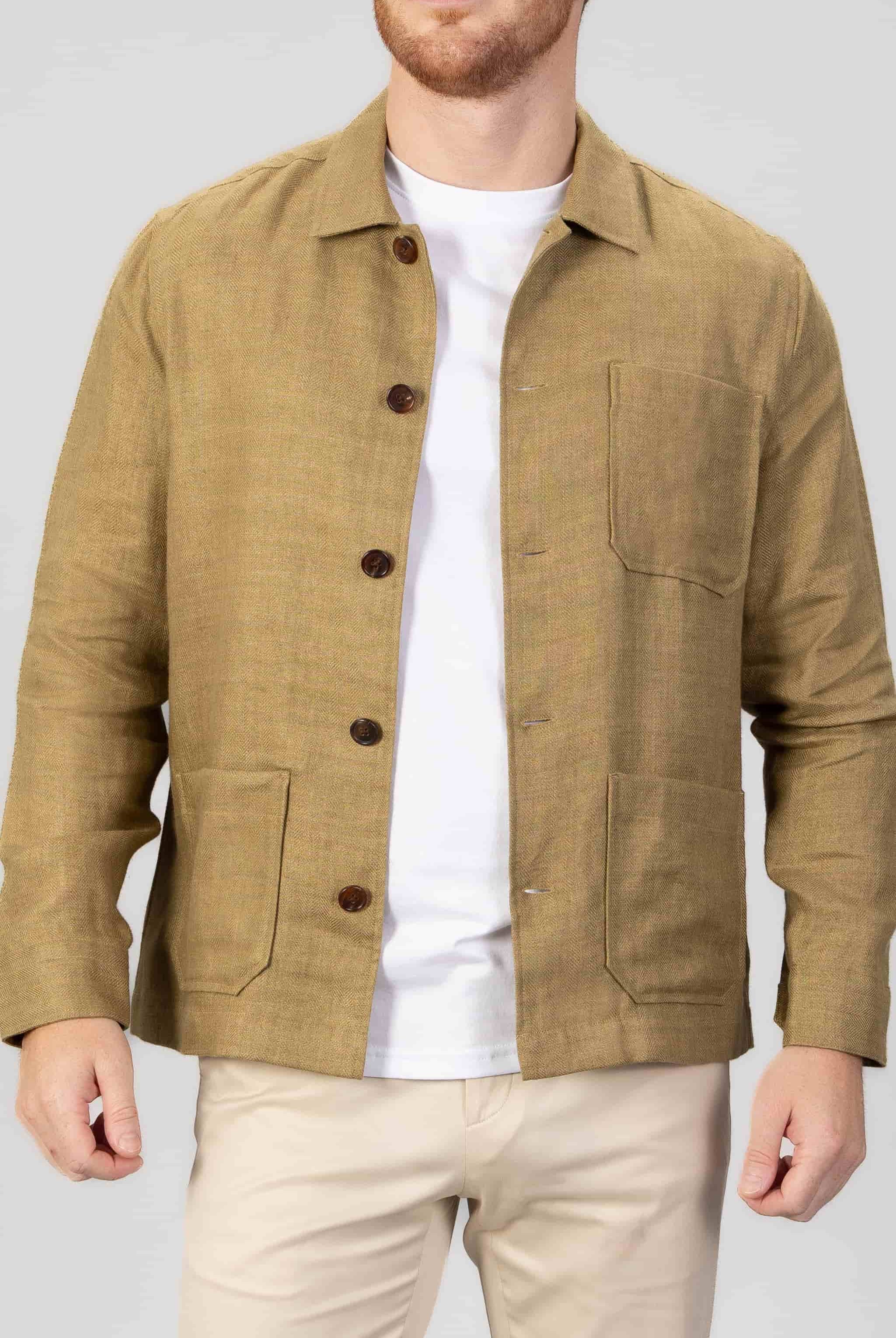 Man wearing a copper brown overshirt over a white t-shirt, with light gray bacground