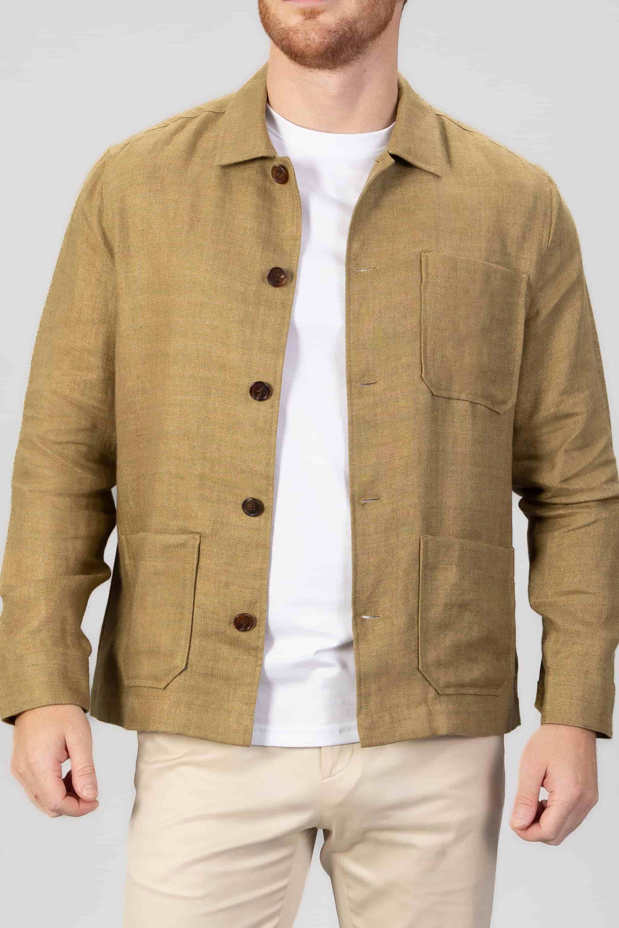 Man wearing a copper brown overshirt over a white t-shirt, with light gray bacground