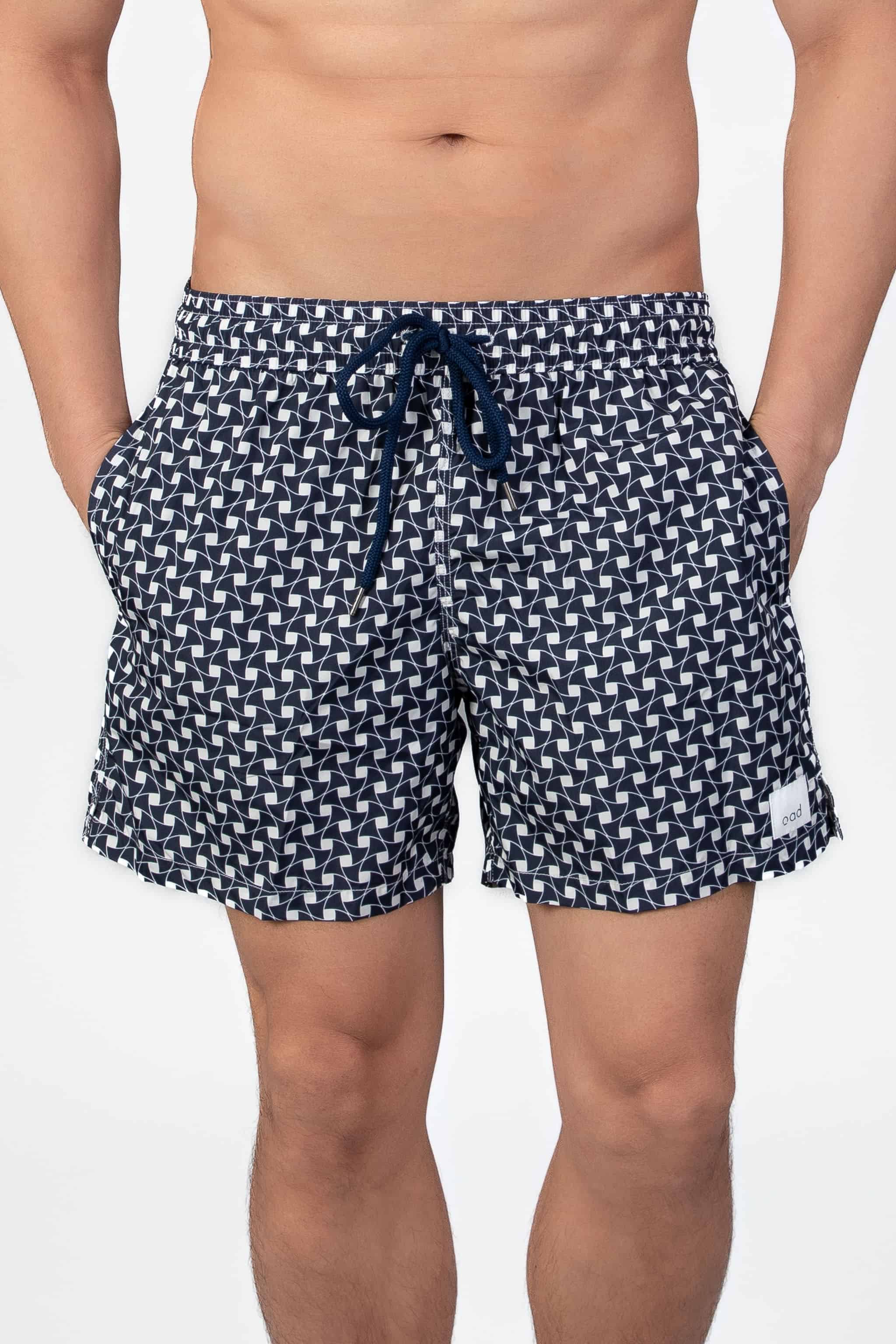 Front view of navy blue swim shorts with a subtle classic pattern and navy string waist closure.