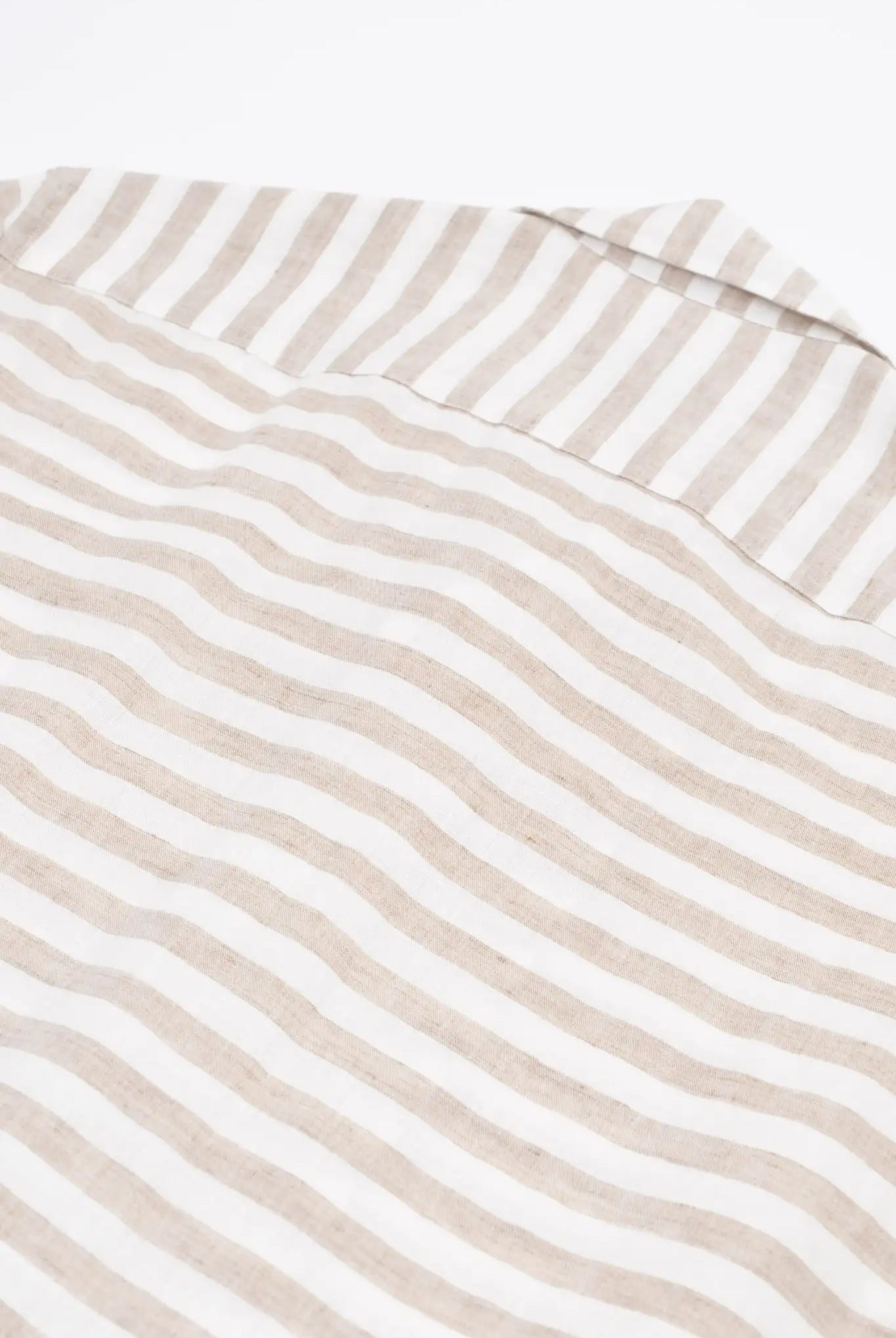 Close-up of a beige and white striped linen shirt