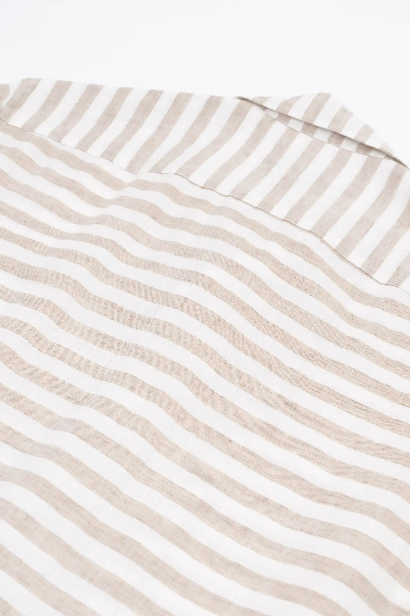 Close-up of a beige and white striped linen shirt