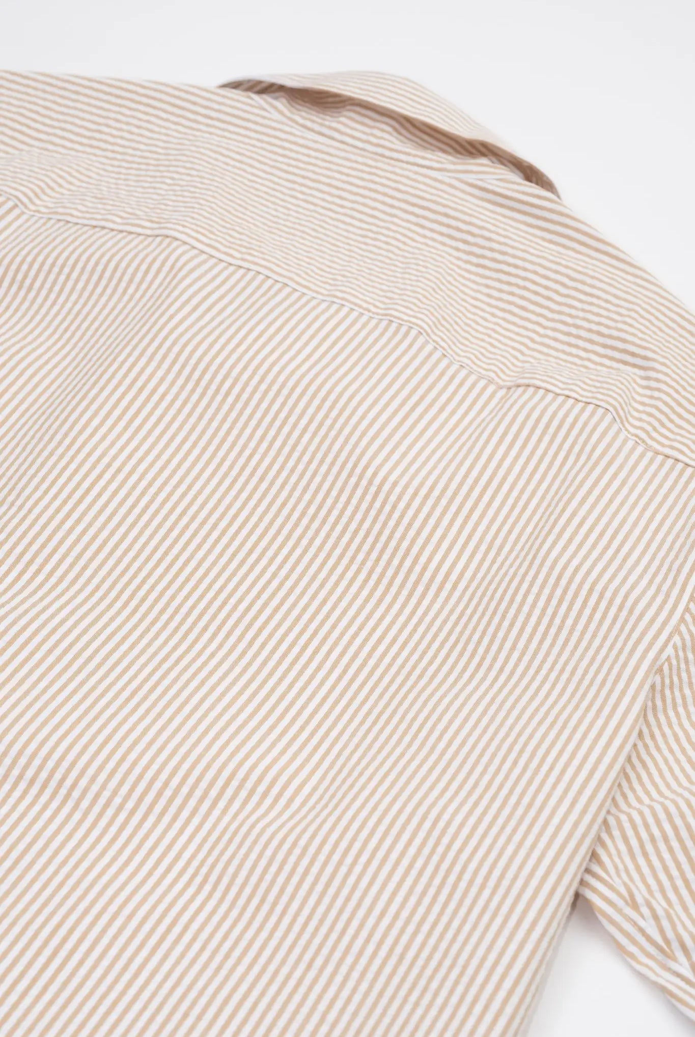 Close-up of a Beige striped camp collar shirt in seersucker fabric on a white background