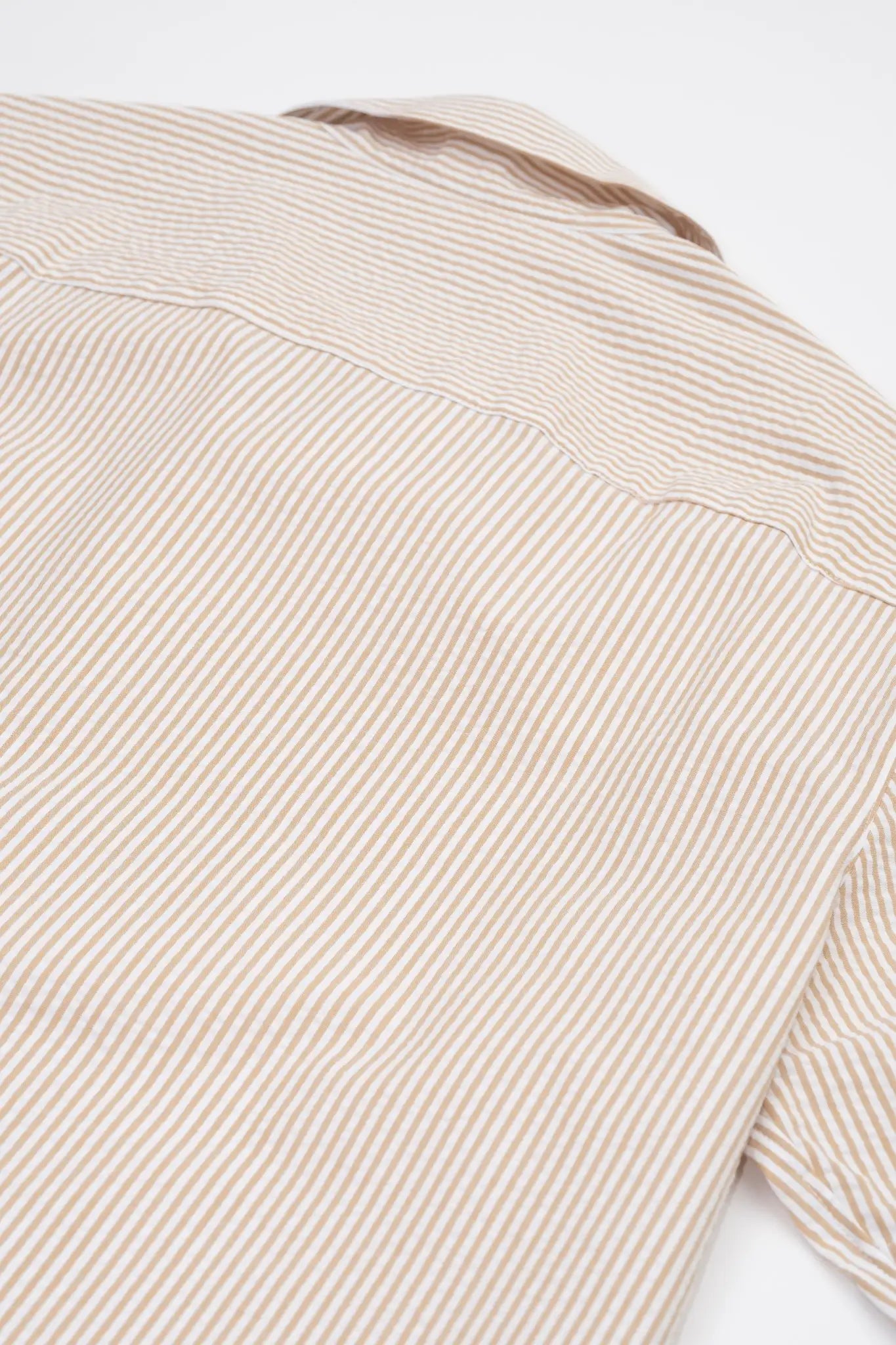Close-up of a Beige striped camp collar shirt in seersucker fabric on a white background