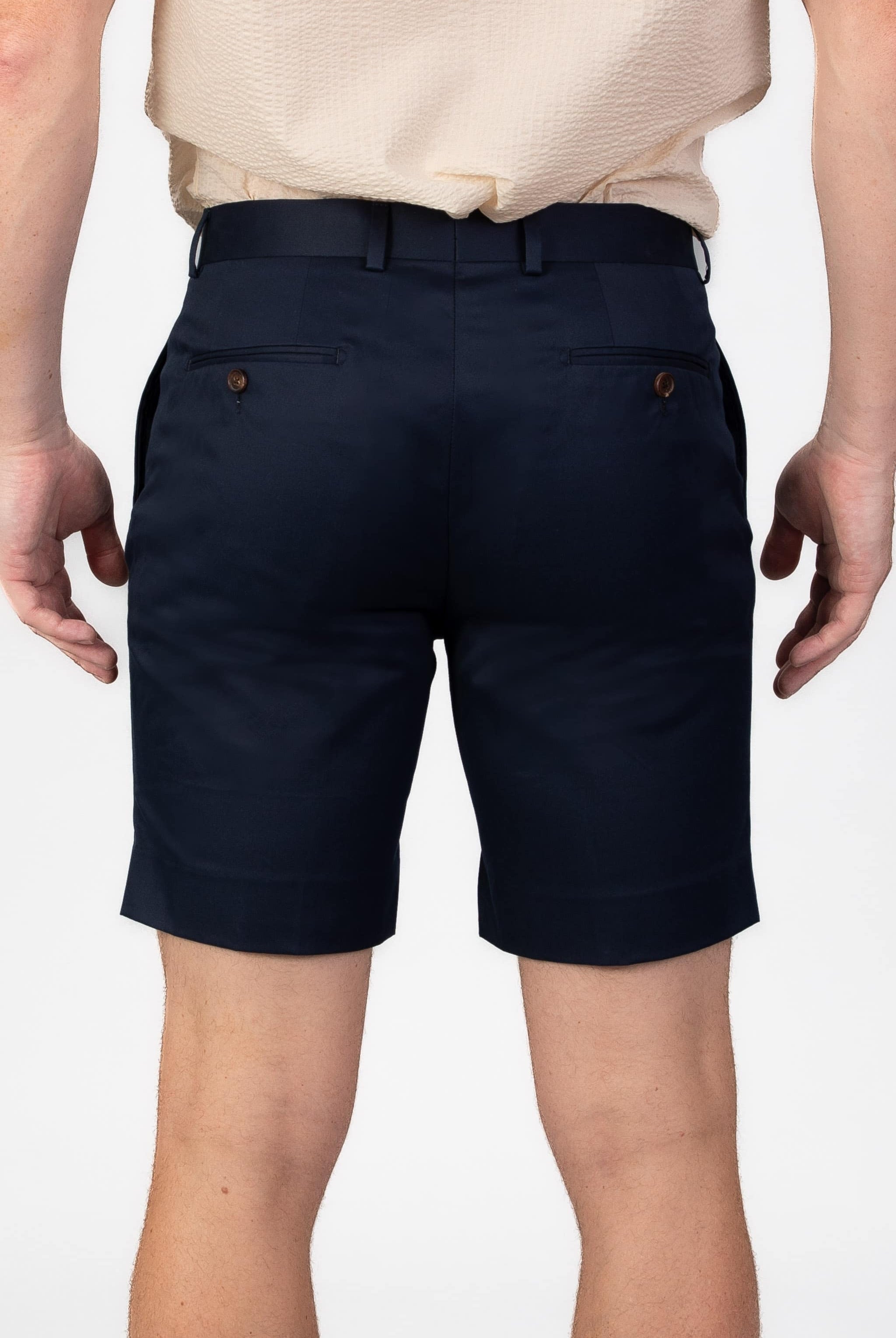 Man wearing navy blue cotton shorts on light gray background