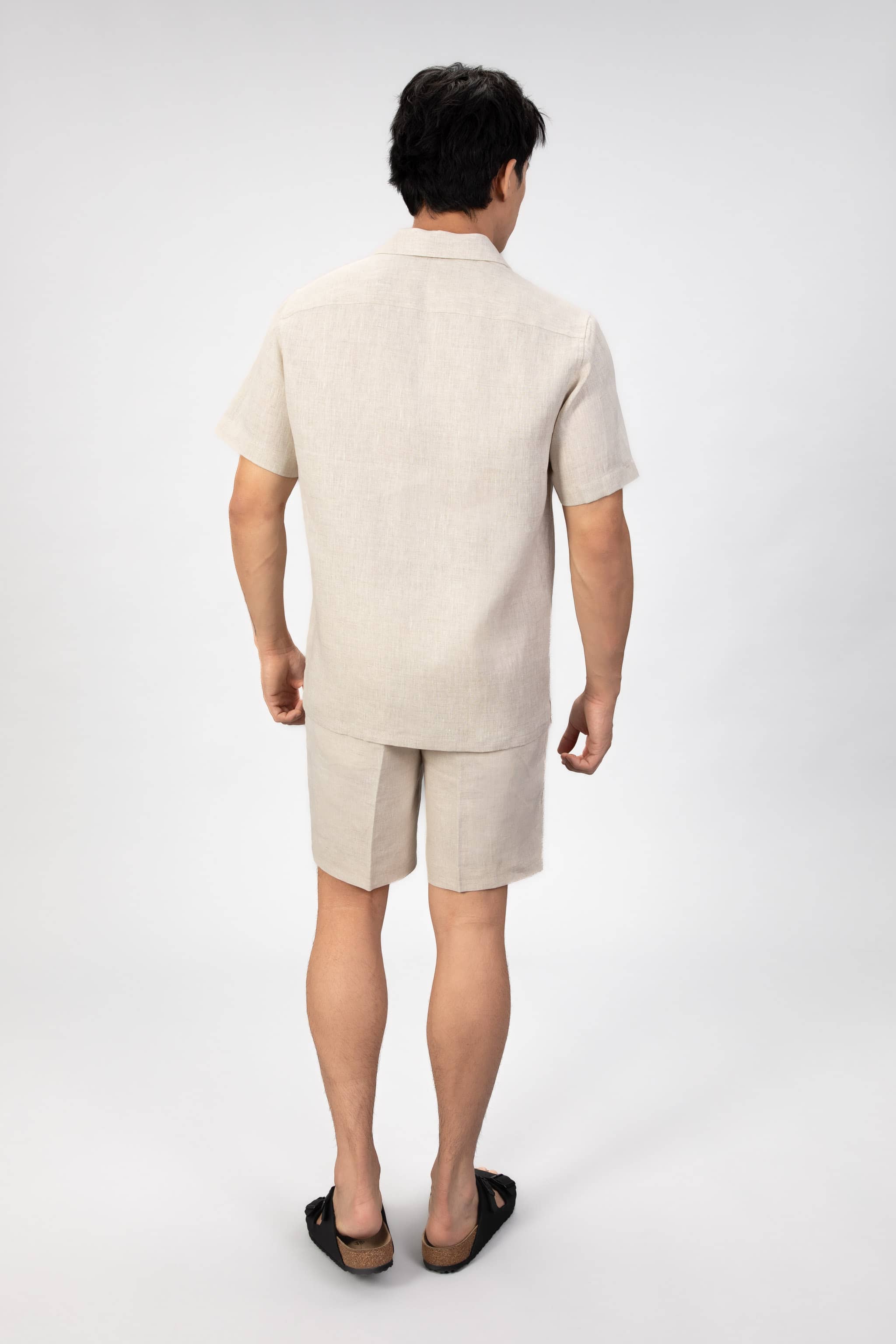 Person wearing a beige outfit on a white background