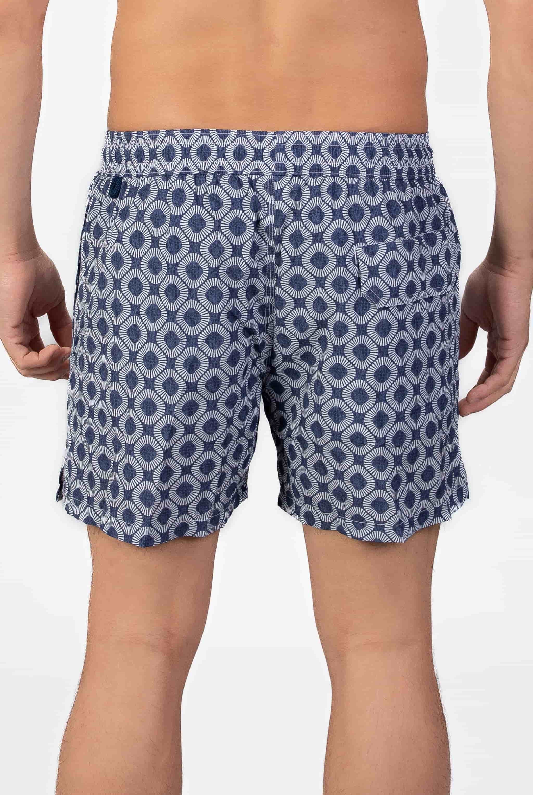 Person wearing blue patterned shorts in navy blue seersucker fabric with a magnetic back pocket on a plain background