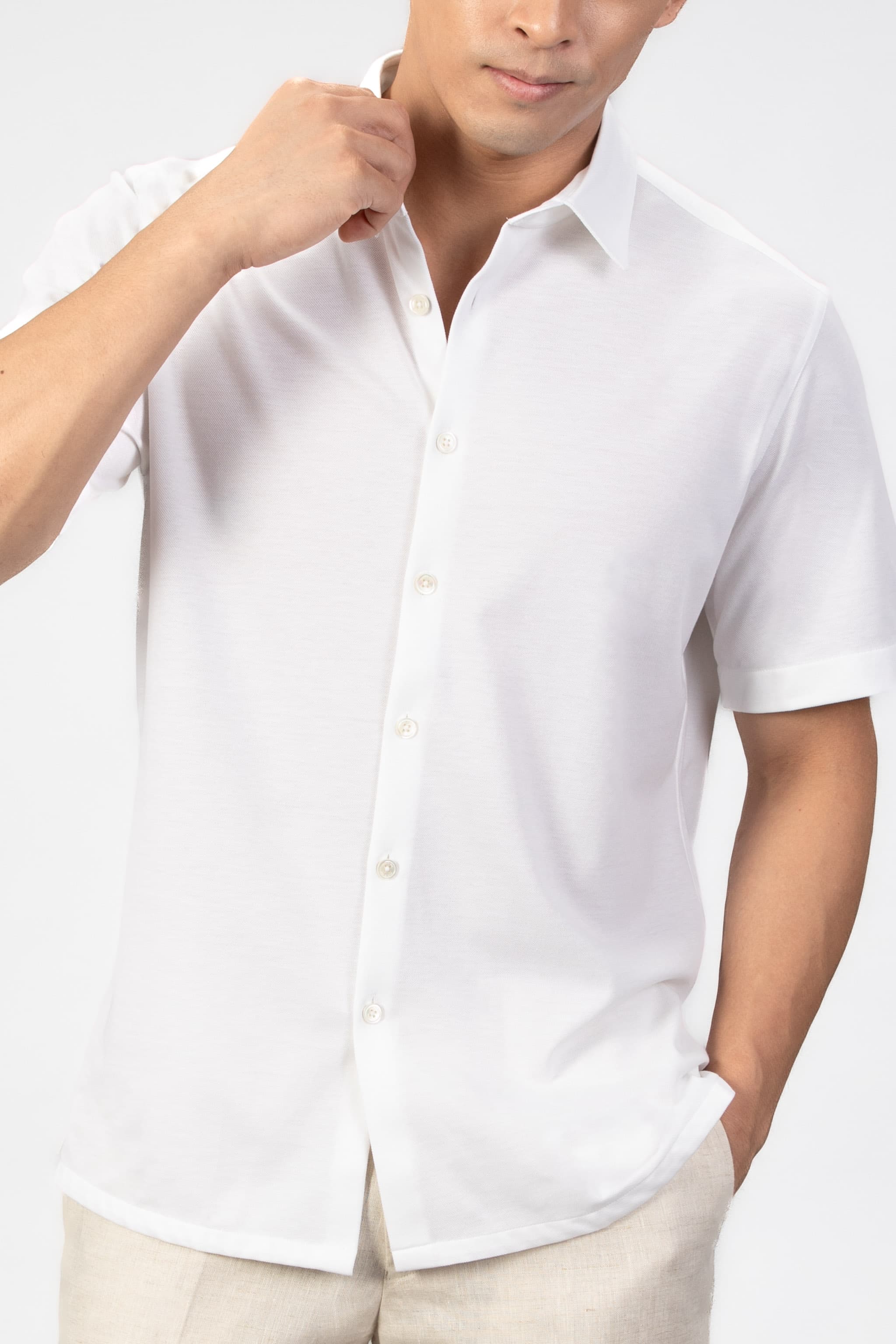 Man wearing a white short-sleeve shirt against a plain background