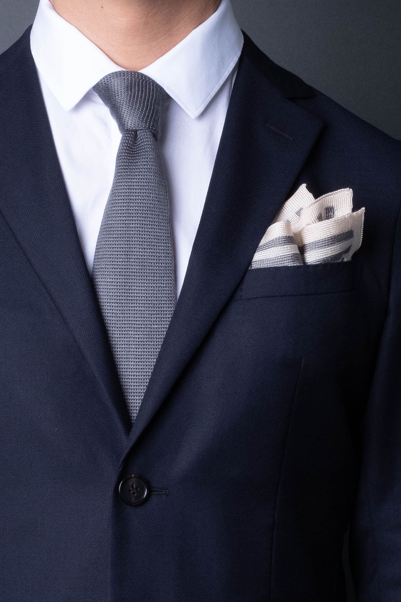 Gray and white striped knitted silk pocket square. Made in Italy paired with Matching tie.