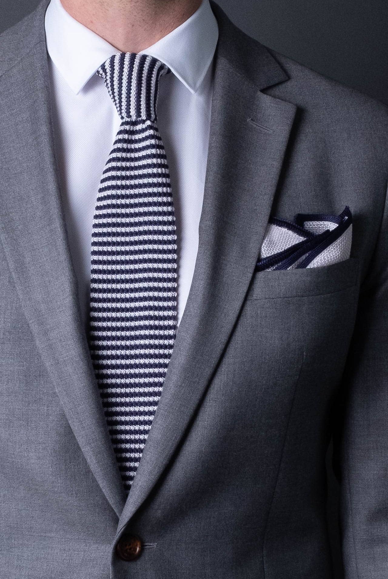 White knitted silk pocket square with navy blue frame. Made in Italy paired with Matching tie.