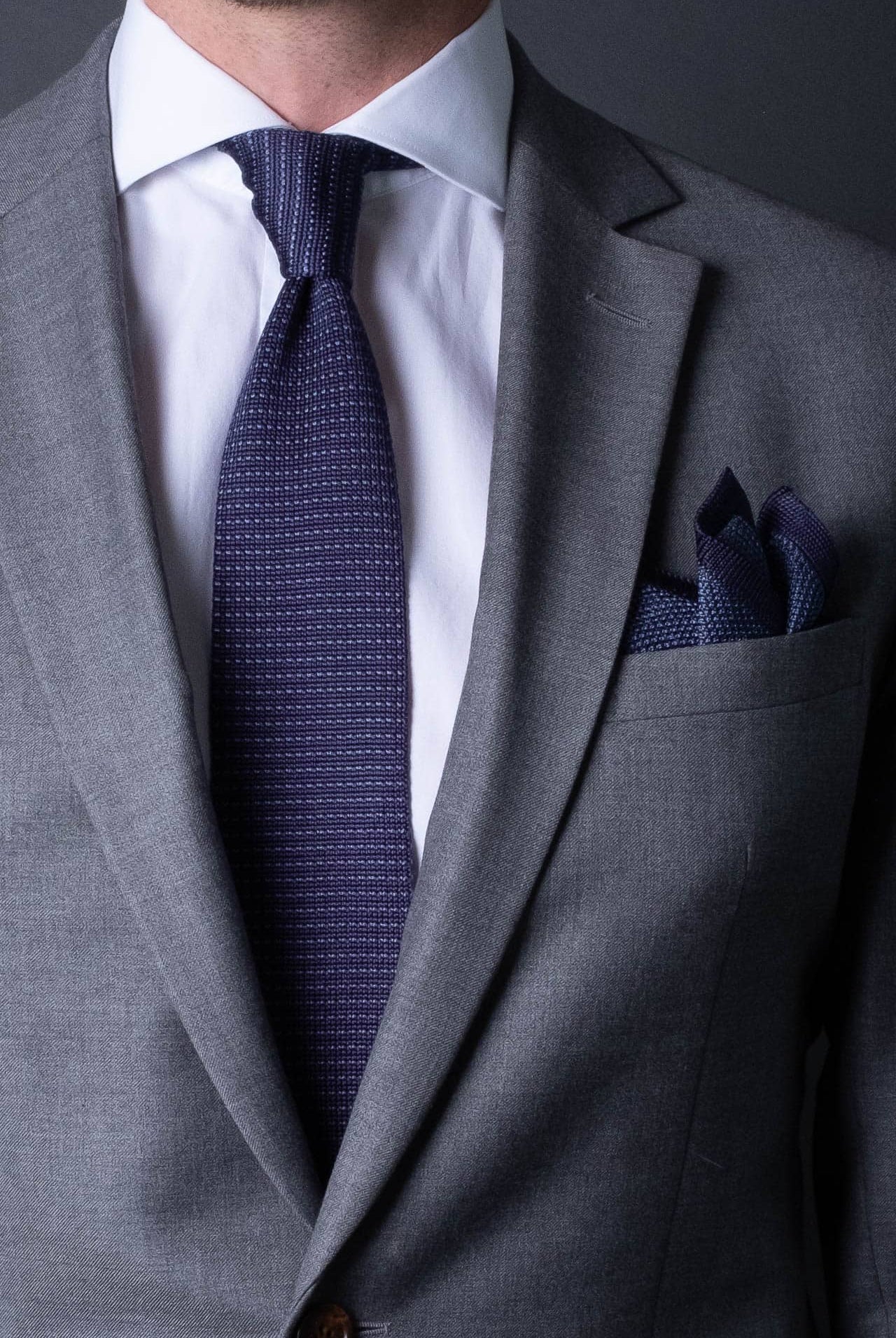 Blue knitted pocket square with navy blue boarder. Made of silk in Italy paired with Matching tie.
