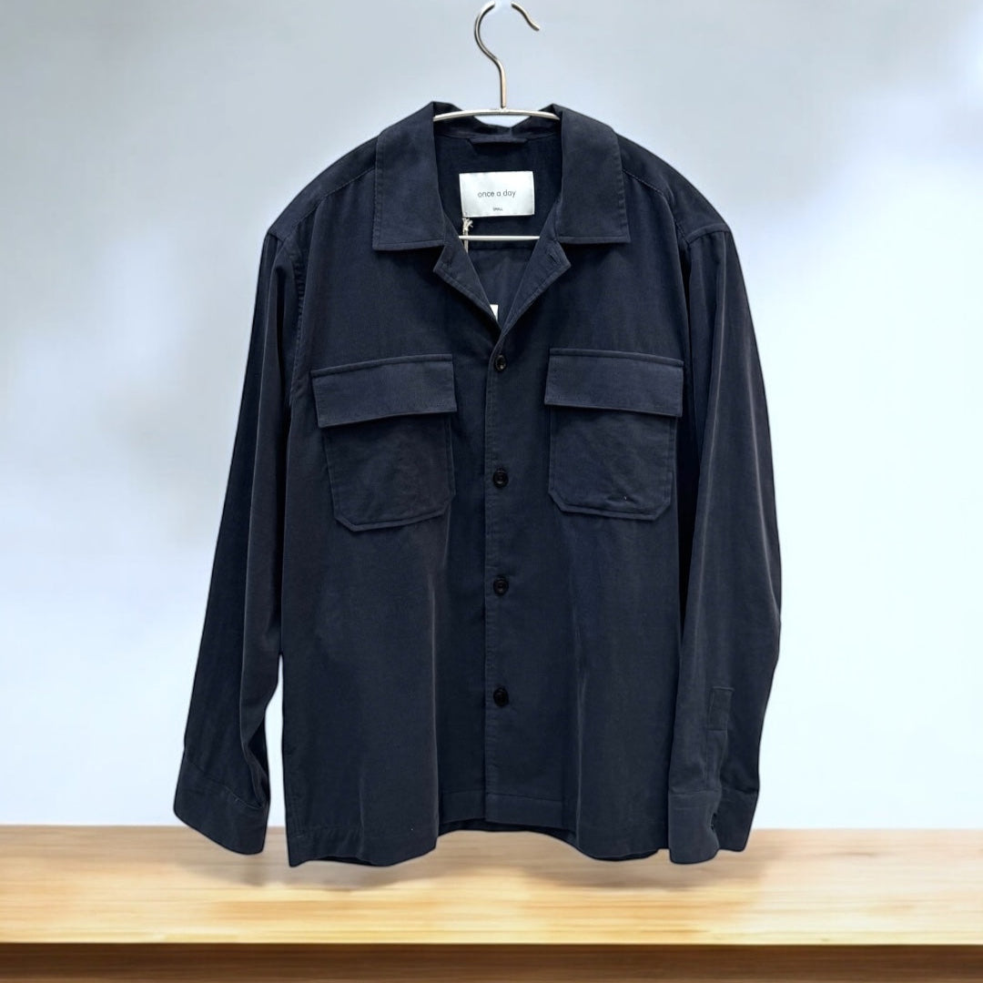 Dark Gray cordroy overshirt on a hanger against a white wall