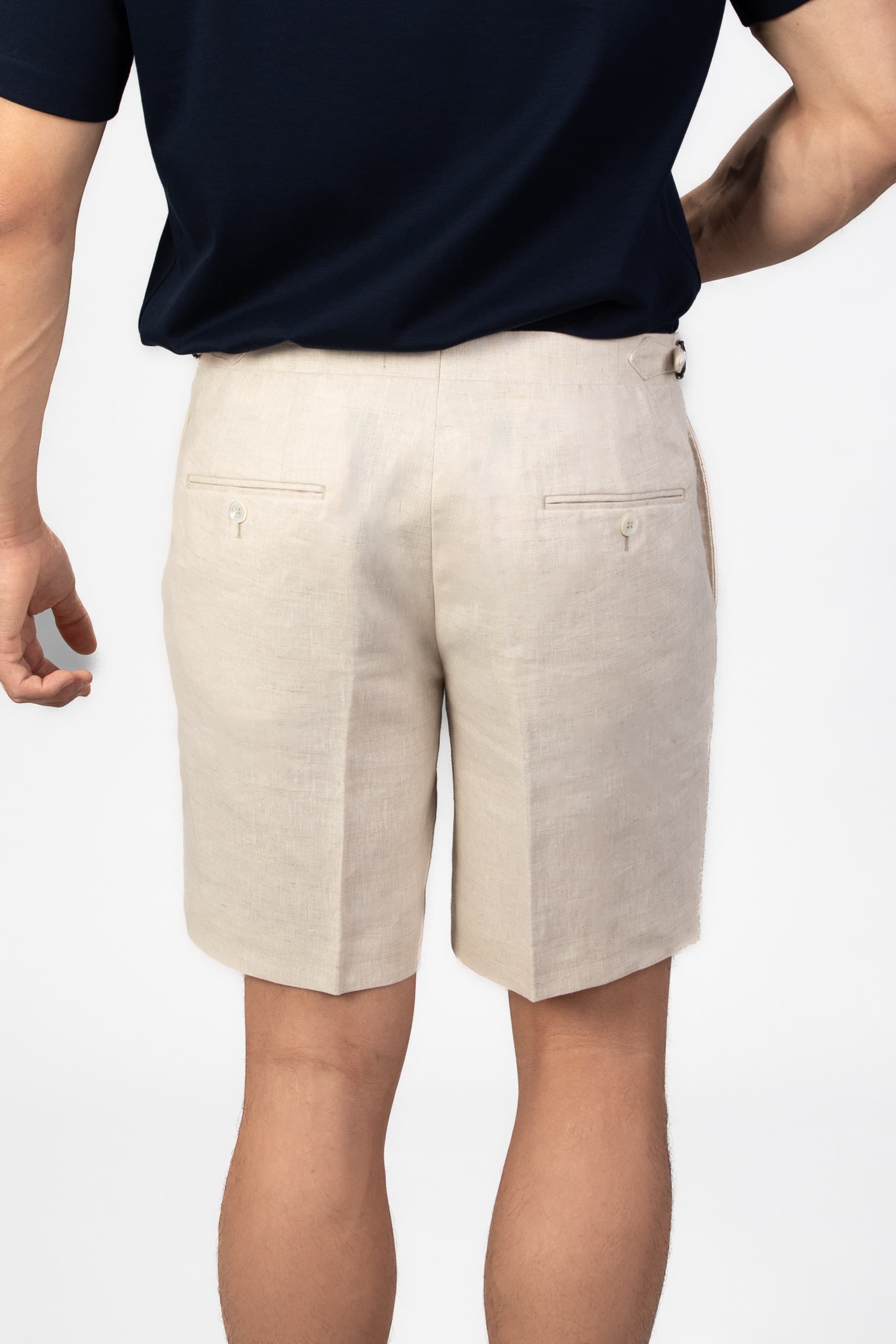 Beige shorts worn by a person on a white background