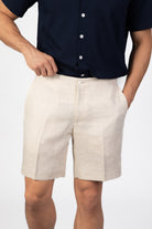 Person wearing beige shorts and a navy shirt on a white background