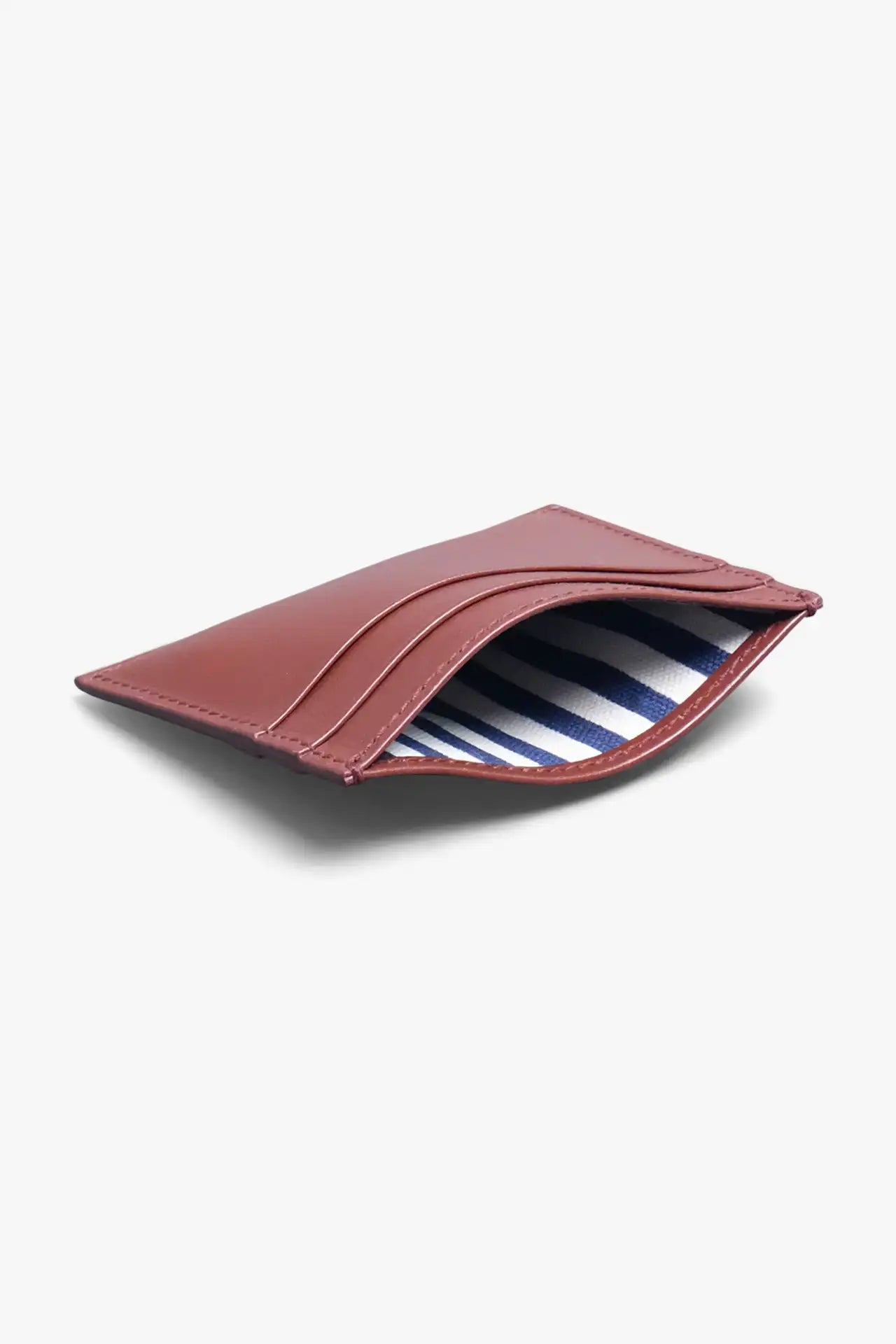 Brown card holder in vegetable tanned leather with a light gray background