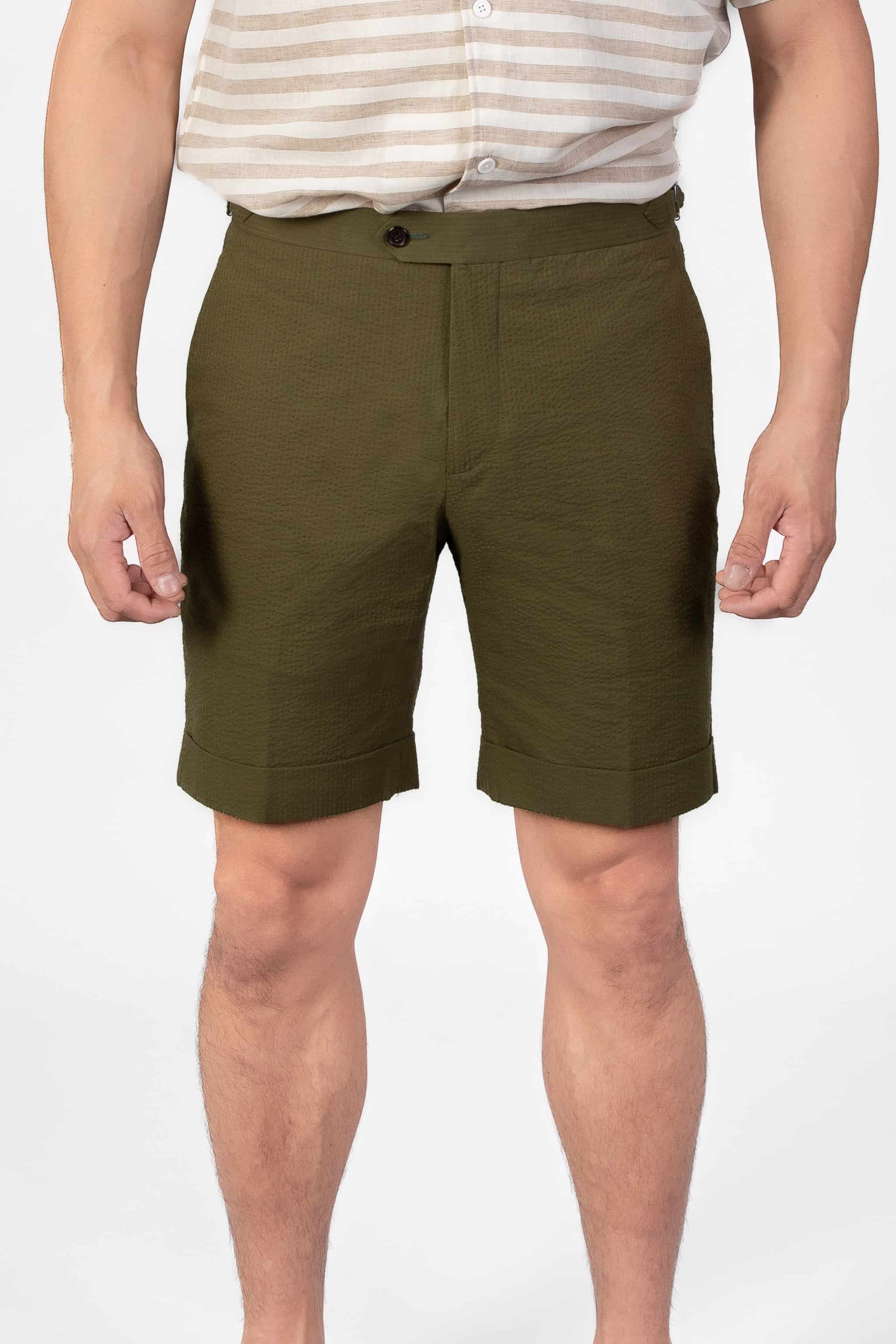 Man wearing a green seersucker shorts on a light gray background