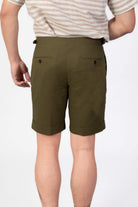 Man wearing a green seersucker shorts with two back pockets on a light gray background
