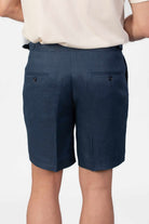 Person wearing linen navy shorts on a light gray background