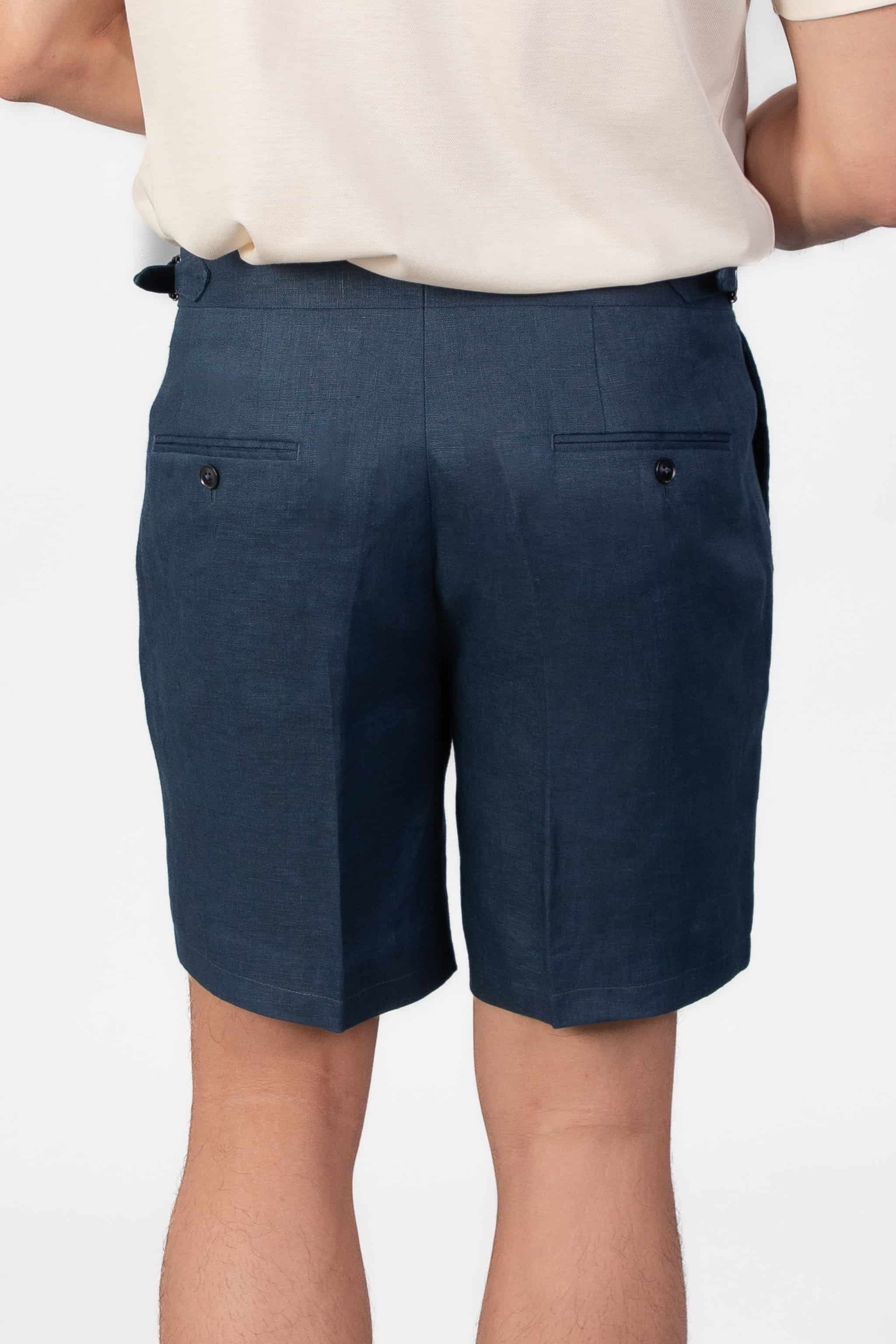 Person wearing linen navy shorts on a light gray background