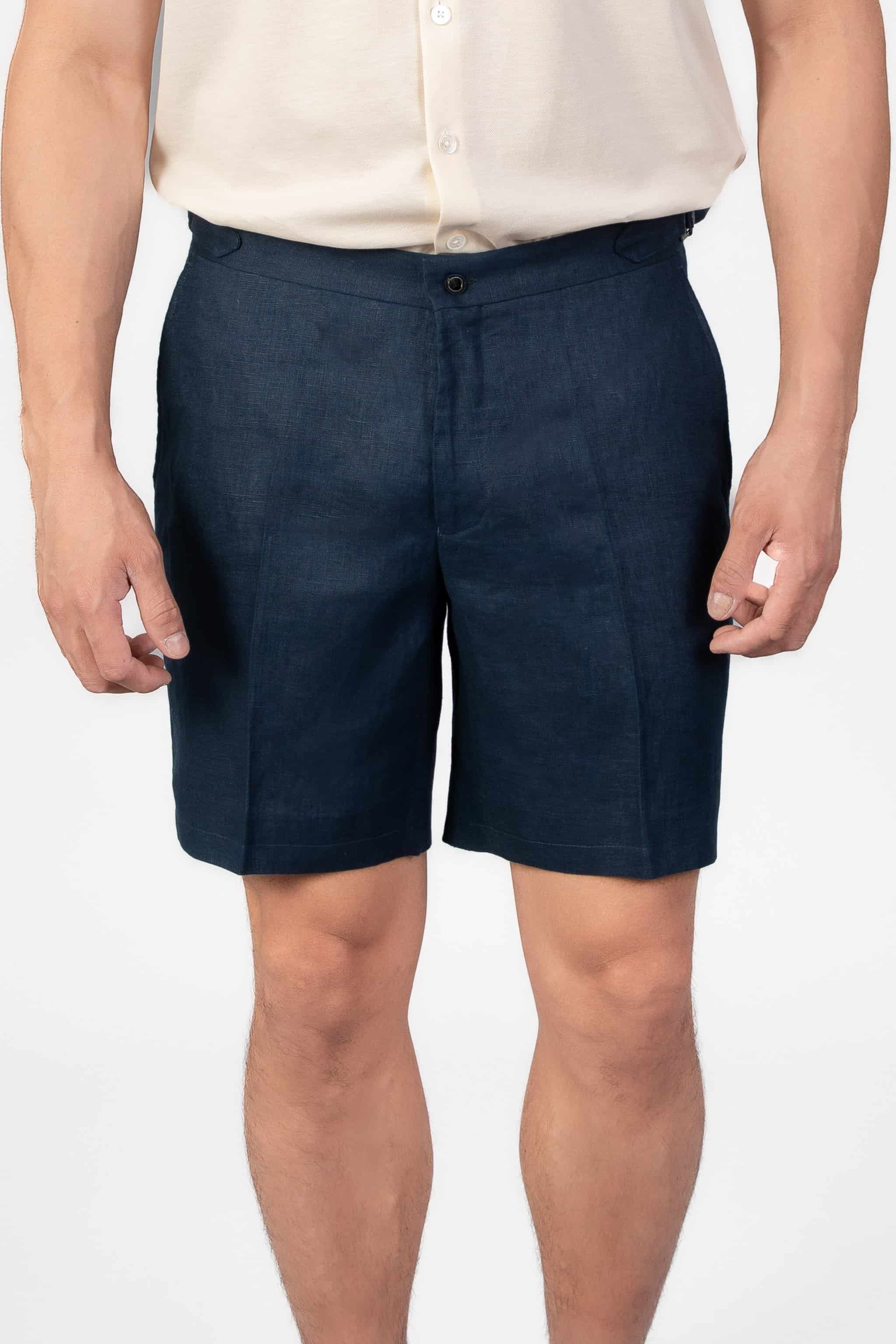 Person wearing linen navy shorts on a light gray background