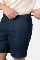 Man wearing navy blue linen shorts with side adjsuters