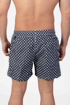Back view of navy blue swim shorts with a subtle classic pattern and back pocket detail closing with a magnet.