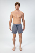 Front view of person wearing classic high end navy swim shorts with a white pattern and drawstring. Made in Italy