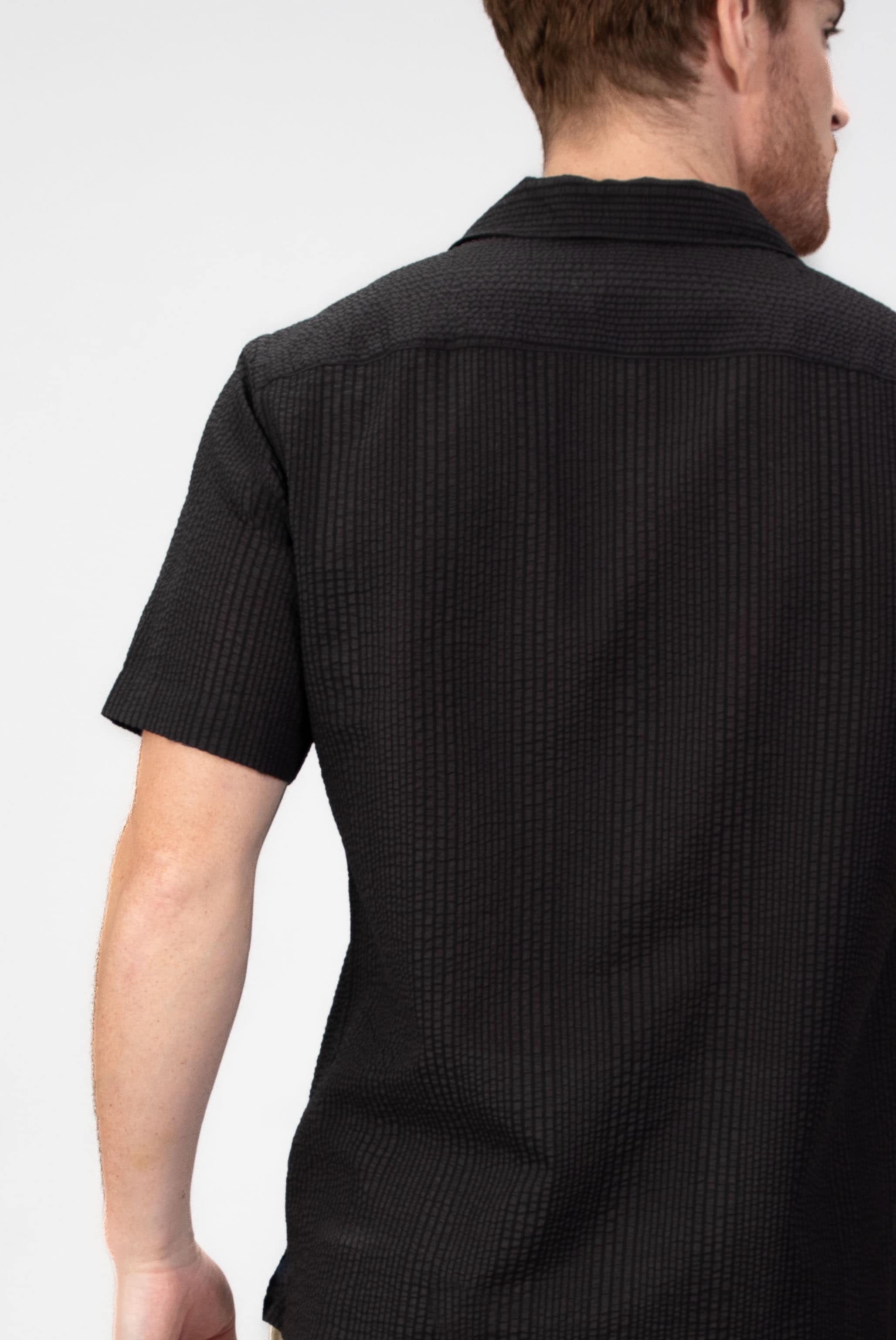 Person wearing a black short-sleeve shirt on a white background