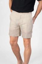 Beige pinstripe shorts worn by a person on a light gray background
