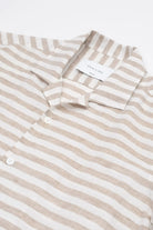 Beige and white striped linen shirt on a white background