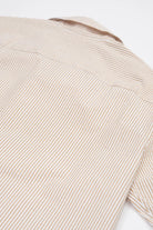 Close-up of a Beige striped camp collar shirt  in seersucker fabric on a white background