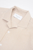 Beige striped camp collar shirt  in seersucker fabric on a white background