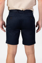 Man wearing navy blue cotton shorts on light gray background