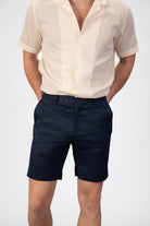 Man wearing navy blue cotton shorts on light gray background