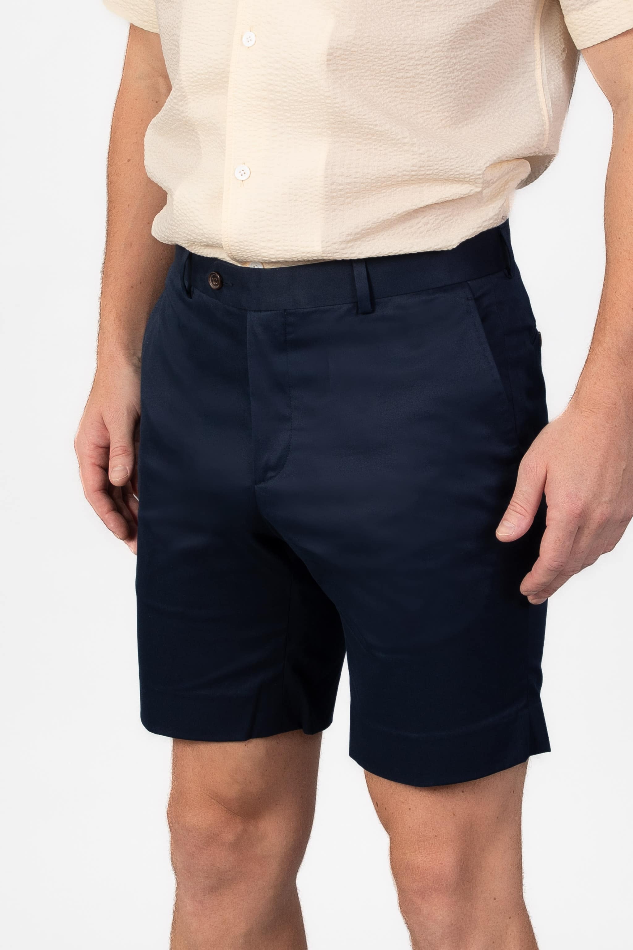 Man wearing navy blue cotton shorts on light gray background