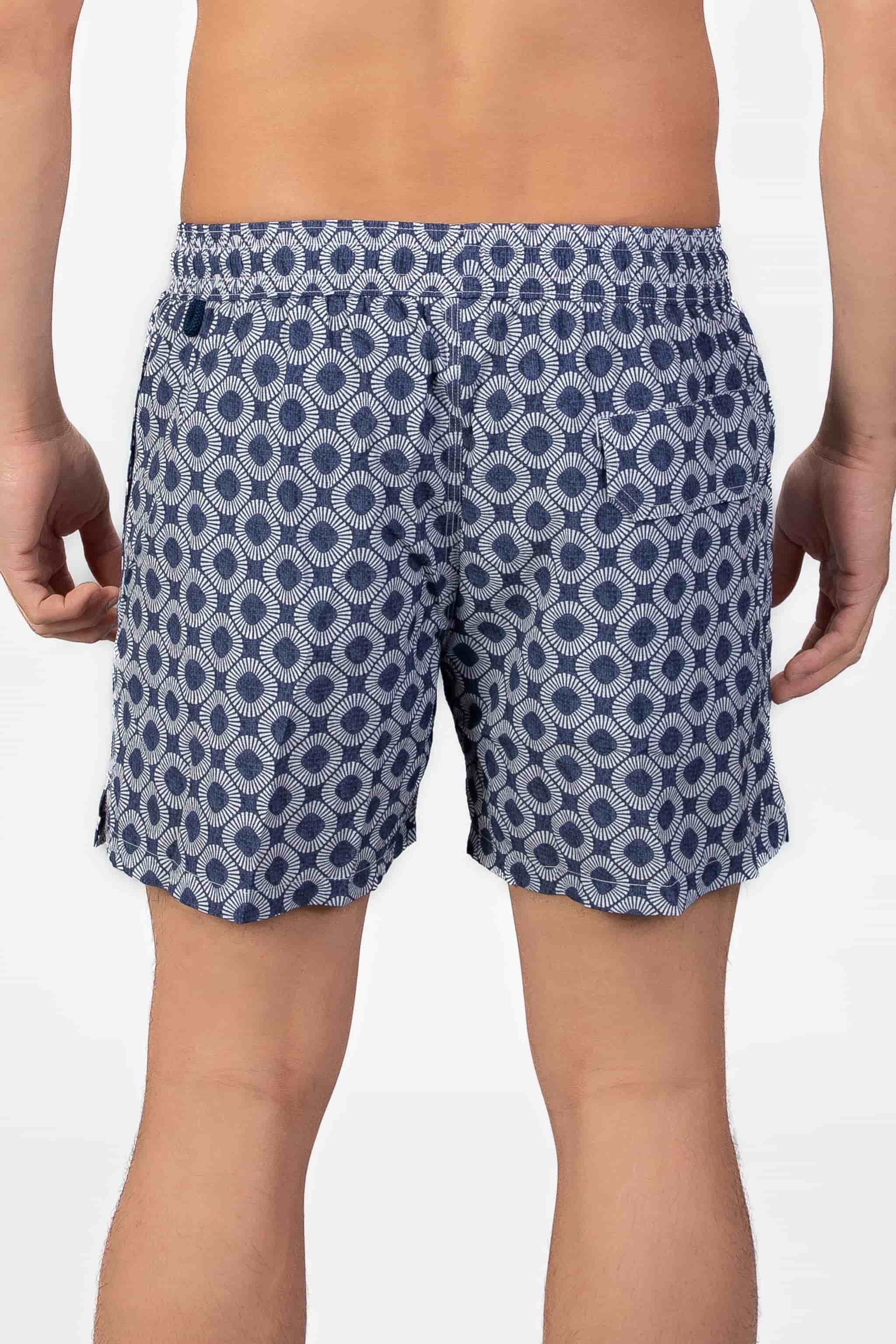 Person wearing blue patterned shorts in navy blue seersucker fabric with a magnetic back pocket on a plain background