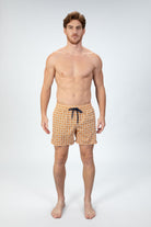 Person wearing stylish orange pattern seersucker swim shorts, front view showing the drawstring closure in navy and textured fabric.