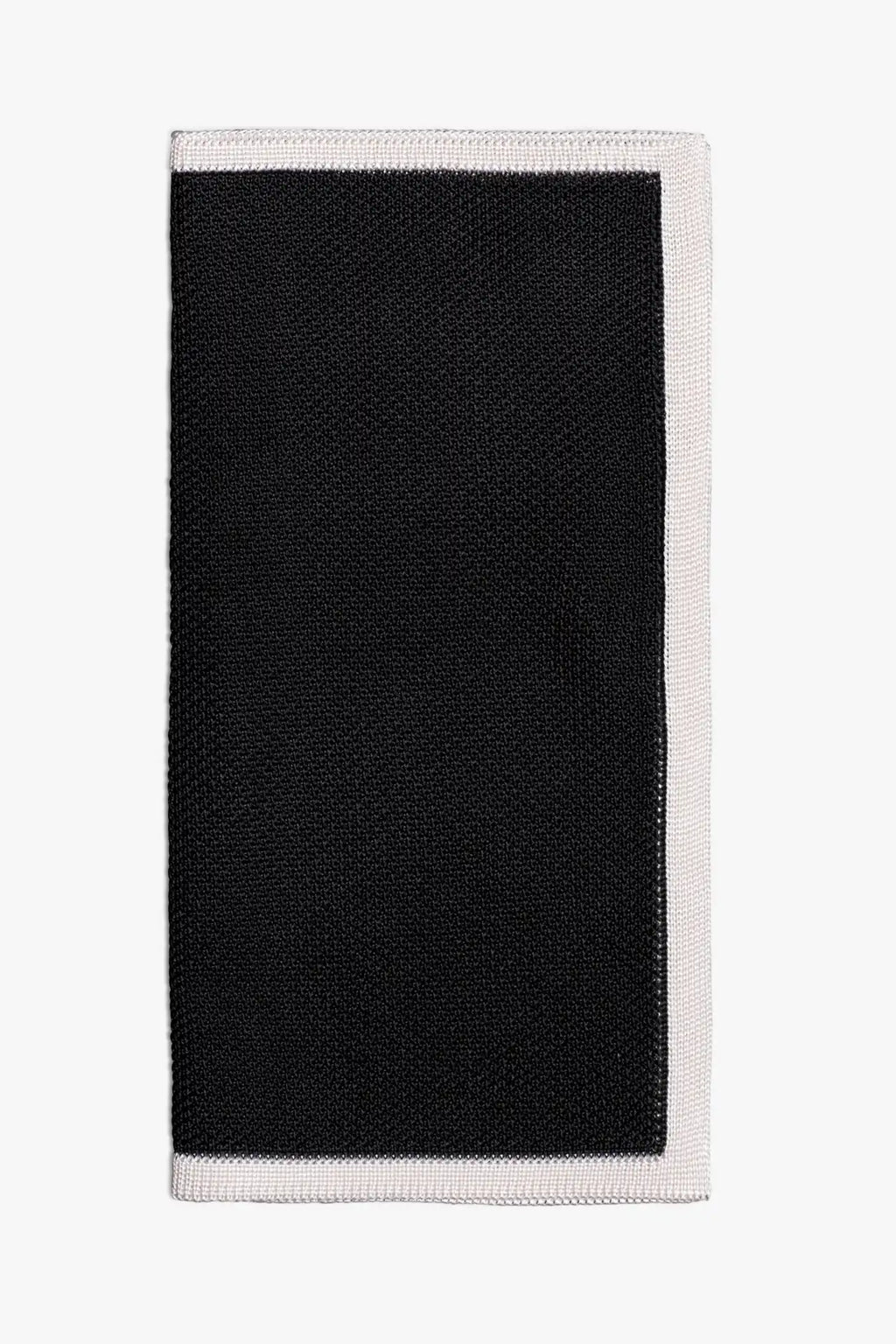 Black knitted pocket square with white frame. Made of silk in Italy paired with Matching tie.