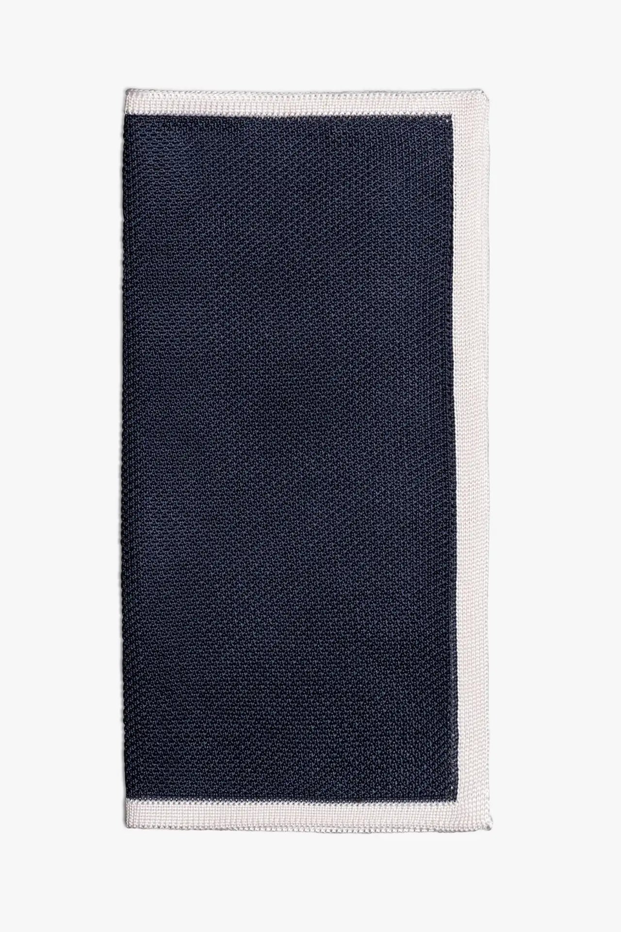 Navy blue knitted pocket square with white boarder. Made of silk in Italy.