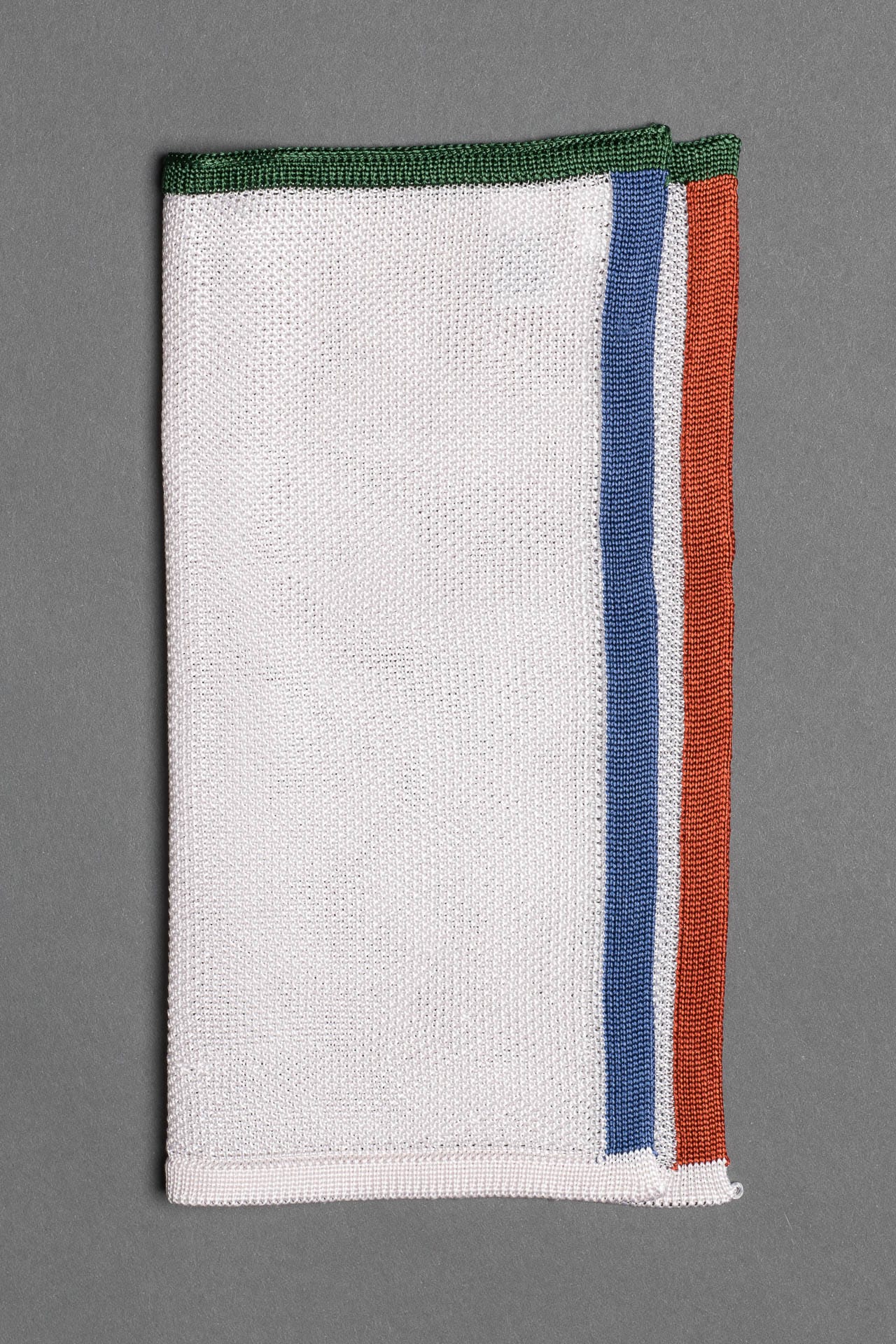 White pocket square with orange, blue and green boarder. Knitted silk made in Italy.