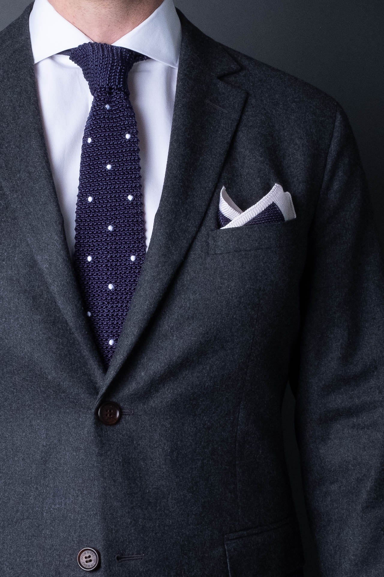 Navy blue knitted pocket square with white boarder. Made of silk in Italy paired with Matching tie.
