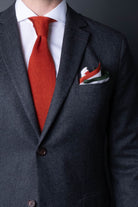 White pocket square with orange, blue and green boarder. Knitted silk made in Italy with matching tie.