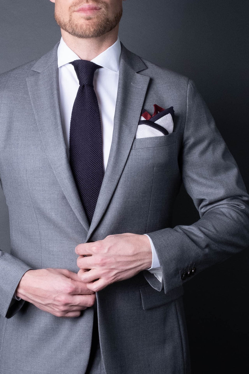 White pocket square with navy blue and red boarder. Knitted silk made in Italy with matching tie.