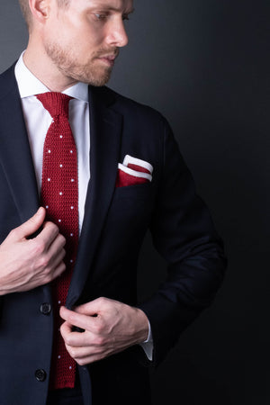 Red knitted pocket square with white frame. Made of silk in Italy paired with Matching tie.