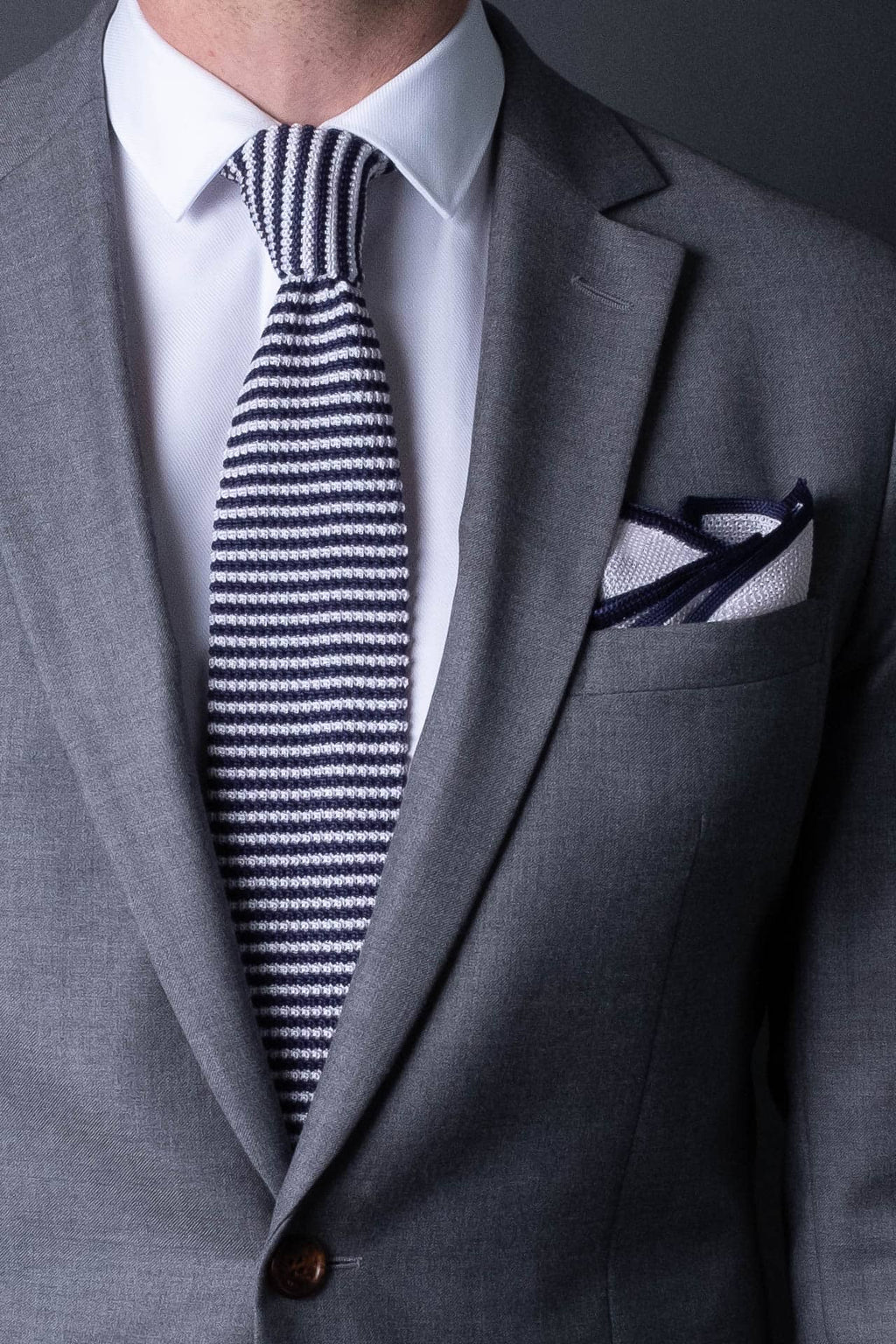 White knitted silk pocket square with navy blue frame. Made in Italy paired with Matching tie.