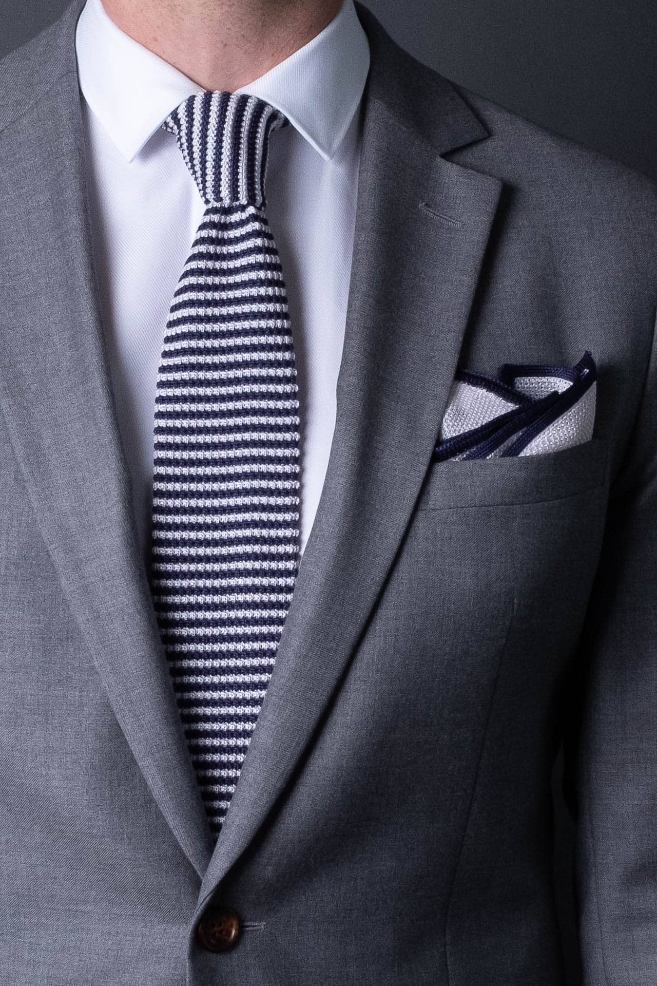 White knitted silk pocket square with navy blue frame. Made in Italy paired with Matching tie.