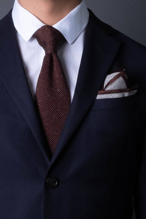 Gray knitted pocket square with brown boarder. Made of silk in Italy paired with Matching tie.